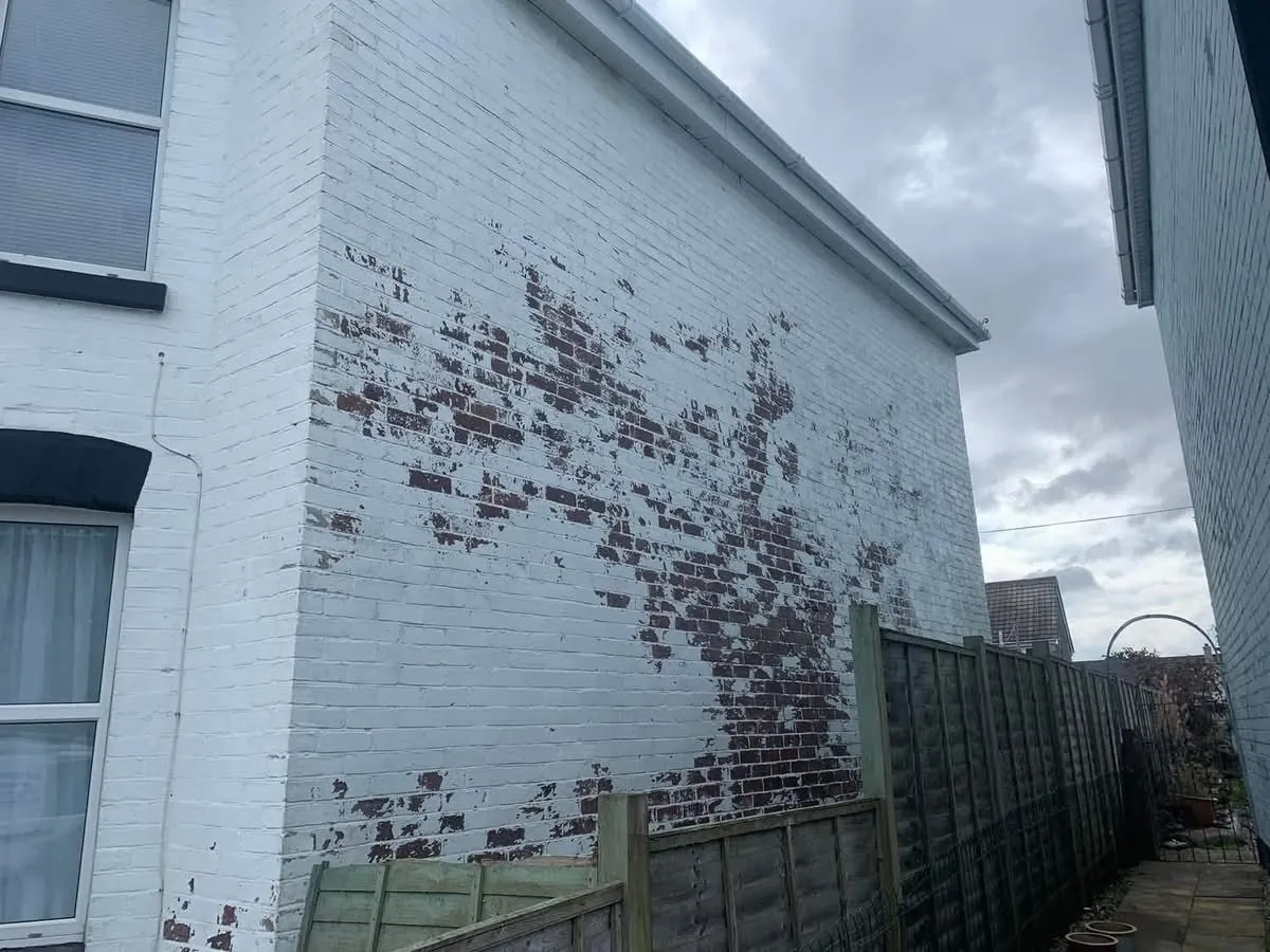 Peeling paint on a brick wall before redecoration in Kingsbridge